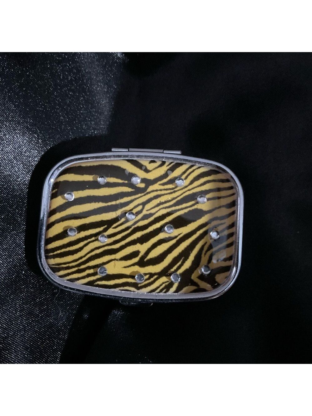 A compact, zebra patterned pill case or travel medicine organizer 1314